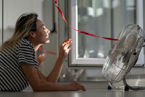 Women Cooling Herself in Front of Desktop Fan - Best Air Conditioner on the Market
