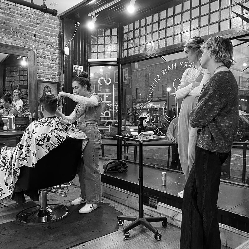 Friends Watching a Stylist Cut Their Friend's Hair - The Refinery Hair Studio West Chester PA