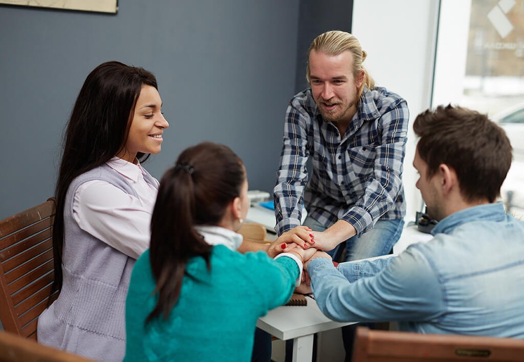 Support System | Four Students Holding Hands in a Circle Supporting One Another