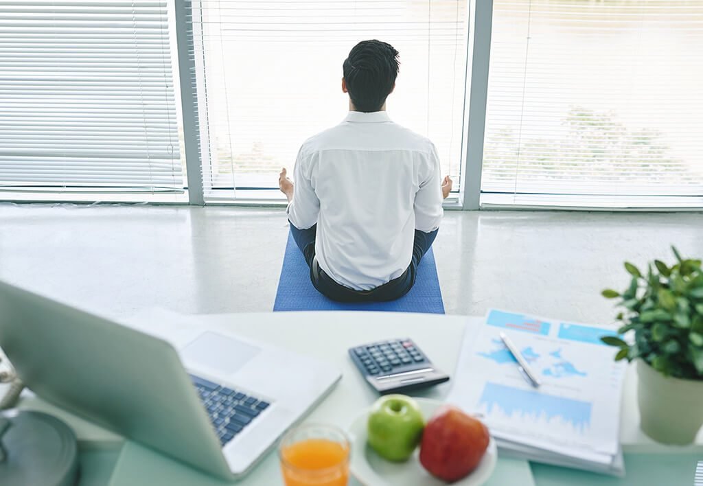 School and Work Balance | Man Taking a Break from His work and Facing a Window Meditating